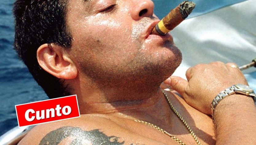 Diego Maradono, smoking a large cigar on a boat